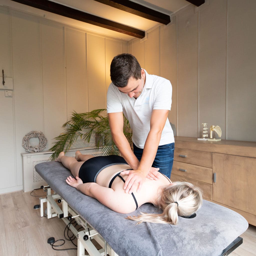 Osteopaat behandelt vrouw aan de schouders